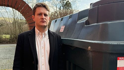 David Chadwick MP infront of heating oil tank