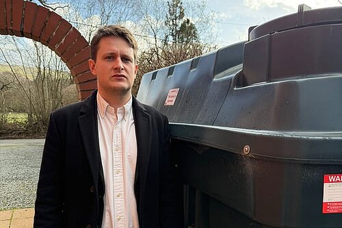 David Chadwick MP infront of heating oil tank