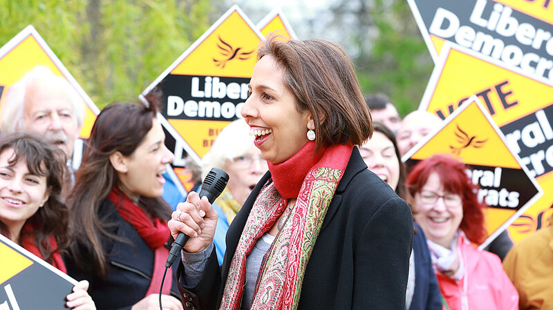 Munira Wilson in front of a crowd holding Liberal Democrat posters