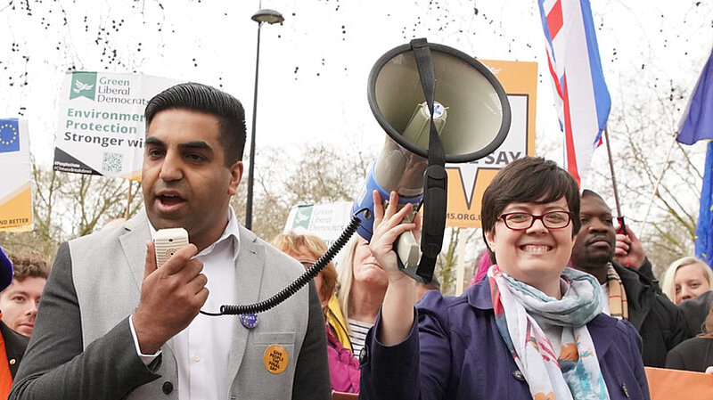 A man speaking into a megaphone held by a woman